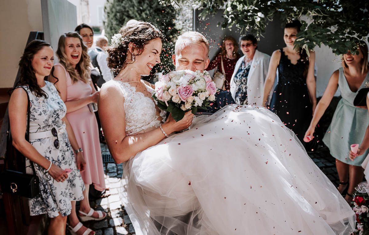 svatba na Velehradě-ženich nese nevěstu přes práh-svatebčani házejí konfety na novomanželé-pavelphotography.cz